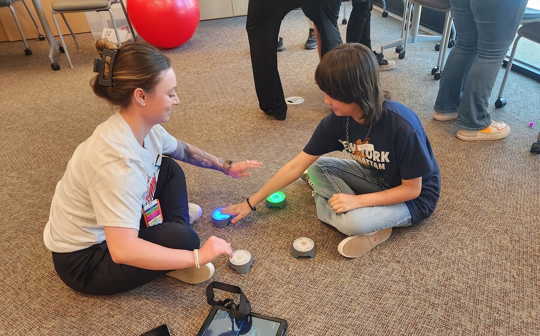 Adult and child sitting on the floor playing a game